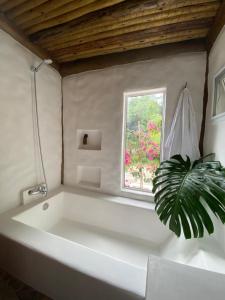 a white bath tub in a bathroom with a window at Villaggio Serra da Cantareira in Mairiporã