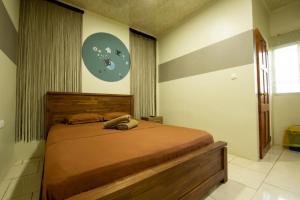 ein Schlafzimmer mit einem großen Bett in einem Zimmer in der Unterkunft Rumanija's Airport Rooms in Zanderij