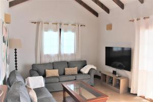 ein Wohnzimmer mit einem Sofa und einem TV in der Unterkunft Villa Turqué in Arrieta
