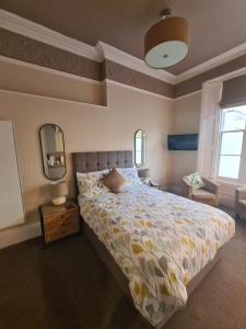 a bedroom with a bed and two mirrors at Meadowside Holiday Apartments in Torquay