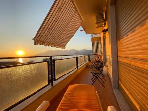een balkon met een bank en uitzicht op de oceaan bij SEA4USALERNO seafront in Salerno