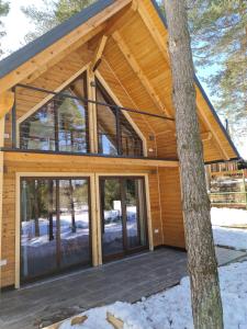Casa con techo de madera y puertas de cristal en HIŠA ZIMAZAKON BLOKE en Nova Vas