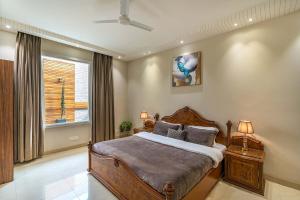 ein Schlafzimmer mit einem großen Bett und einem Fenster in der Unterkunft StayVista's D'Amour - Amritsar Haven with Outdoor Deck & Indoor Entertainment in Amritsar