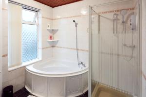 a bathroom with a tub and a glass shower at Home away from Home in Beeston