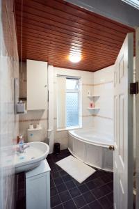 a white bathroom with a tub and a sink at Home away from Home in Beeston