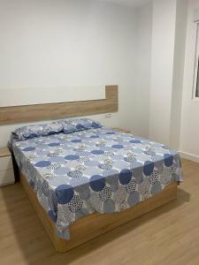 Un dormitorio con una cama con un edredón azul y blanco. en Mateos, en Murcia