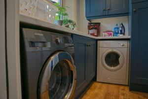 a washer and dryer in a blue laundry room at Irish Sea Cottage in Annalong
