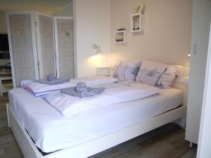 Una cama blanca con toallas encima. en Strandperle 5, en Scharbeutz