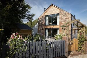 a brick house with a fence in front of it at Daisy Cottage, Dalston, Nr Carlisle in Carlisle