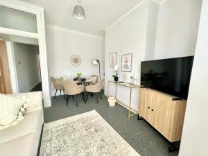 uma sala de estar com uma grande televisão e uma mesa em Stunning Flat Close to Beach em Swansea