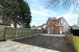 a detached house with a fence and a driveway at Green Garden in Northwest London in London