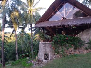 a building with palm trees in front of it at Villa Pintu Bintang in Pawenang