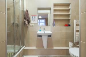 La salle de bains est pourvue d'un lavabo, d'une douche et de toilettes. dans l'établissement Villa Oliva, à Gdańsk