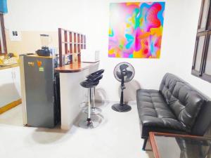 a living room with a black leather couch and a counter at Apartamento - Centro Histórico 209 San Agustin in Cartagena de Indias