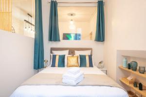 - une chambre avec un lit doté de rideaux bleus dans l'établissement Bohemian Flat - Lovely Marais, à Paris