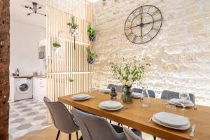 - une salle à manger avec une table et des chaises en bois dans l'établissement Bohemian Flat - Lovely Marais, à Paris