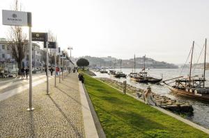 una calle junto a un cuerpo de agua con barcos en Douro River Apartments, en Vila Nova de Gaia