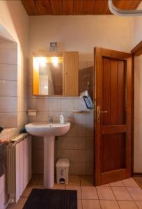 a bathroom with a sink and a mirror and a door at CasaGiulia in Sillano