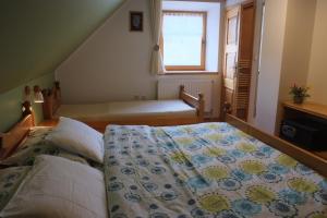 a bedroom with a bed with a quilt on it at Farm Pri Flandru in Cerkno