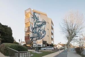 a building with a painting on the side of it at Hôtel Le Collier in Antibes