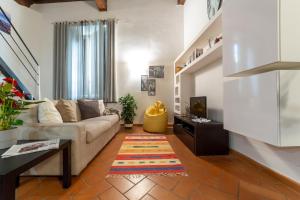 a living room with a couch and a tv at Guelfi loft in a historic palace in Florence