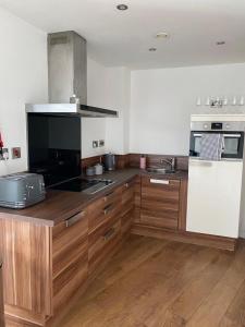 a kitchen with wooden cabinets and a stove top oven at Blonk Street I Quarter Apartment in Sheffield