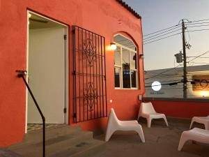 un bâtiment rouge avec deux chaises et une porte dans l'établissement La Estancia Vacation Rentals, à San Juan
