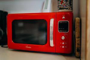 un microondas rojo sentado en la parte superior de un mostrador en A cozy home away from home en Bad Ischl