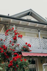 una casa con flores rojas en el balcón en A cozy home away from home en Bad Ischl