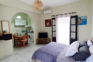 a bedroom with a bed and a table and a kitchen at Cosy Messaria in Mesaria