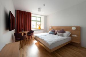 a bedroom with a bed and a table and a window at Hotel Tři knížata in Jihlava +18 photos