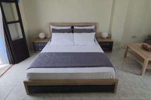 una camera da letto con un grande letto con due tavoli di Cosy Messaria a Mesariá