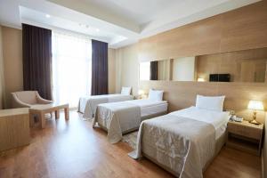Habitación de hotel con 2 camas y ventana en NOBEL Hotel en Baku