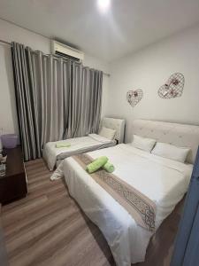 古晉的住宿－P' Residence Condo, Batu Kawa, Kuching，卧室内的两张床,墙上有心