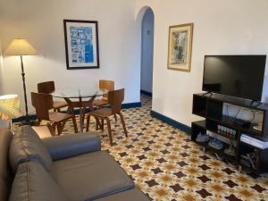 sala de estar con sofá, mesa y TV en La Estancia Vacation Rentals, en San Juan