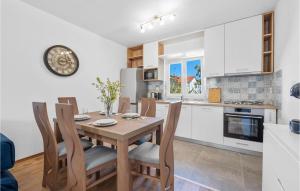 cocina y comedor con mesa de madera y sillas en 2 Bedroom Awesome Home In Betina en Betina