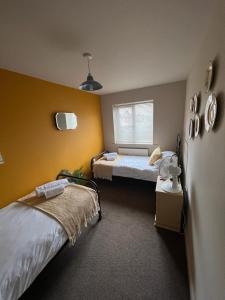 a room with two beds and a window at Goodwins' by Spires Accommodation a comfortable place to stay close to Burton-upon-Trent in Swadlincote