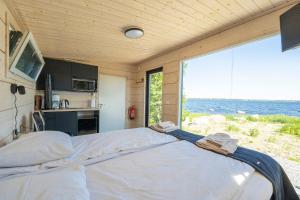 un grande letto in una stanza con una grande finestra di Kipinä Lomat - Loimu-mökki a Sotkamo