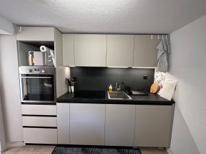 a kitchen with white cabinets and a black counter top at Jonnys Paradisli in Reams