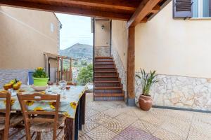 una mesa y sillas en un patio con una escalera en Casa splendida, en Monreale