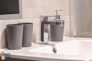 um lavatório de casa de banho com uma torneira e dois rolos de papel higiénico em Michael&Renate - Stylish studio em Trieste