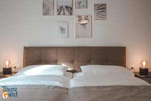 um quarto com uma cama grande com três fotografias na parede em Michael&Renate - Stylish studio em Trieste