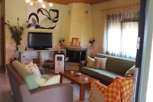 a living room with two couches and a tv at Lefter's Cottege in Nea Irakleia +25 photos