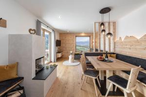 a kitchen and dining room with a table and a fireplace at Apartment Mittermanting in Villnoss