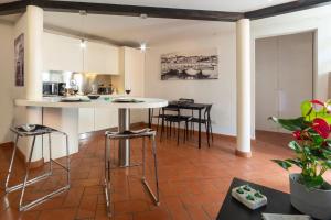 a kitchen and living room with a table and chairs at Guelfi loft in a historic palace in Florence