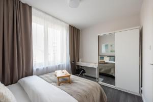 a hotel room with a bed and a mirror at Wola Park Lovely Apartment - near Metro in Warsaw
