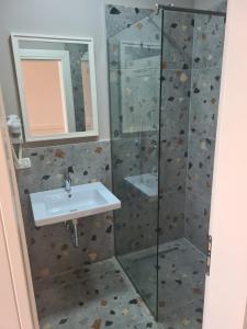 a bathroom with a sink and a shower at Joel Residence in Durr&euml;s