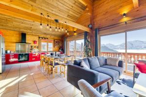 uma sala de estar com um sofá e uma mesa numa cozinha em Alpes Sweet Home - Chalet en 7 em Alpe-d'Huez