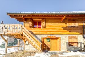 uma cabina de madeira com uma escada que conduz à porta da frente em Alpes Sweet Home - Chalet en 7 em Alpe-d'Huez