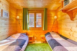 a bedroom with two beds in a log cabin at Alpes Sweet Home - Chalet en 7 in L'Alpe-d'Huez